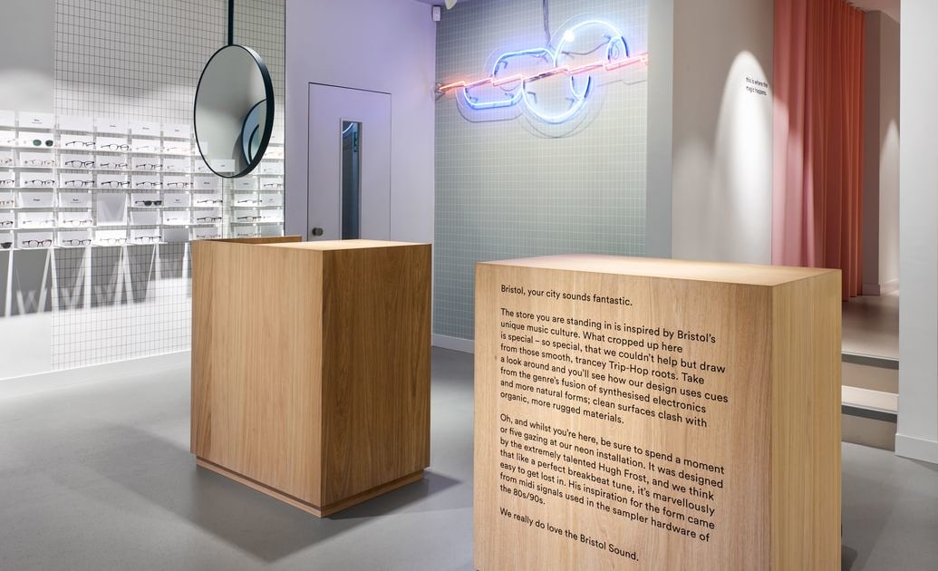 Ace & Tate Park Street store interior with timber plinth, neon installation and 'Bristol Sound' wall text