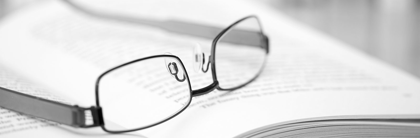 Book with glasses on desk — choosing glasses page banner