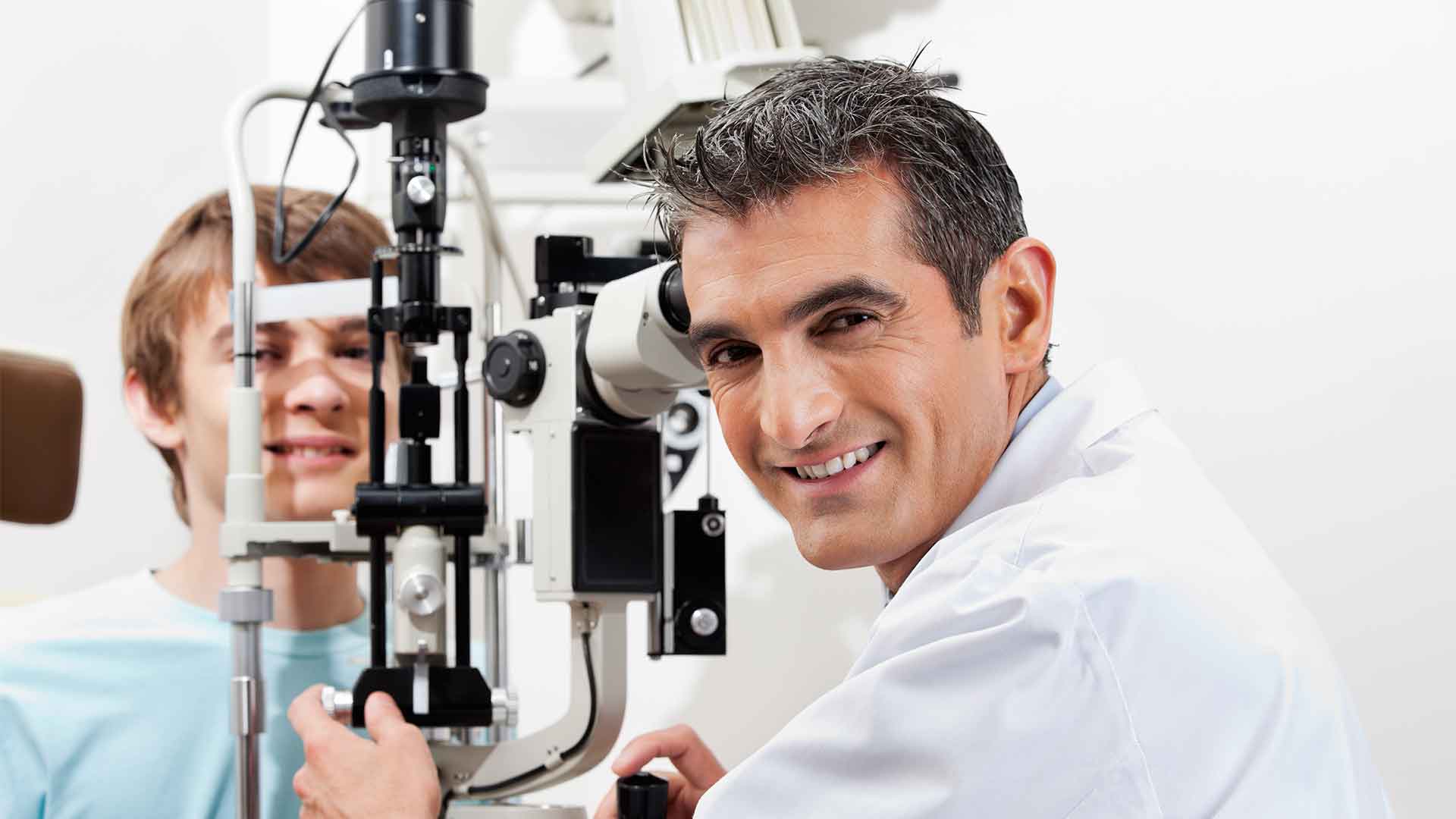 Optician and young patient (about-page marketing image, stock)