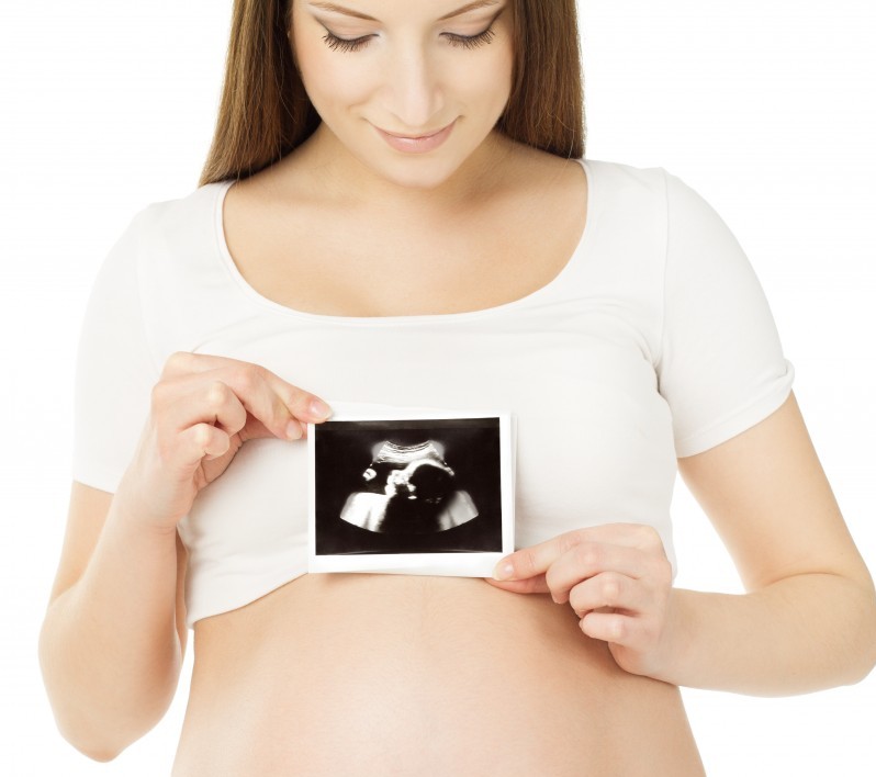Pregnant woman holding ultrasound (fertility theme)