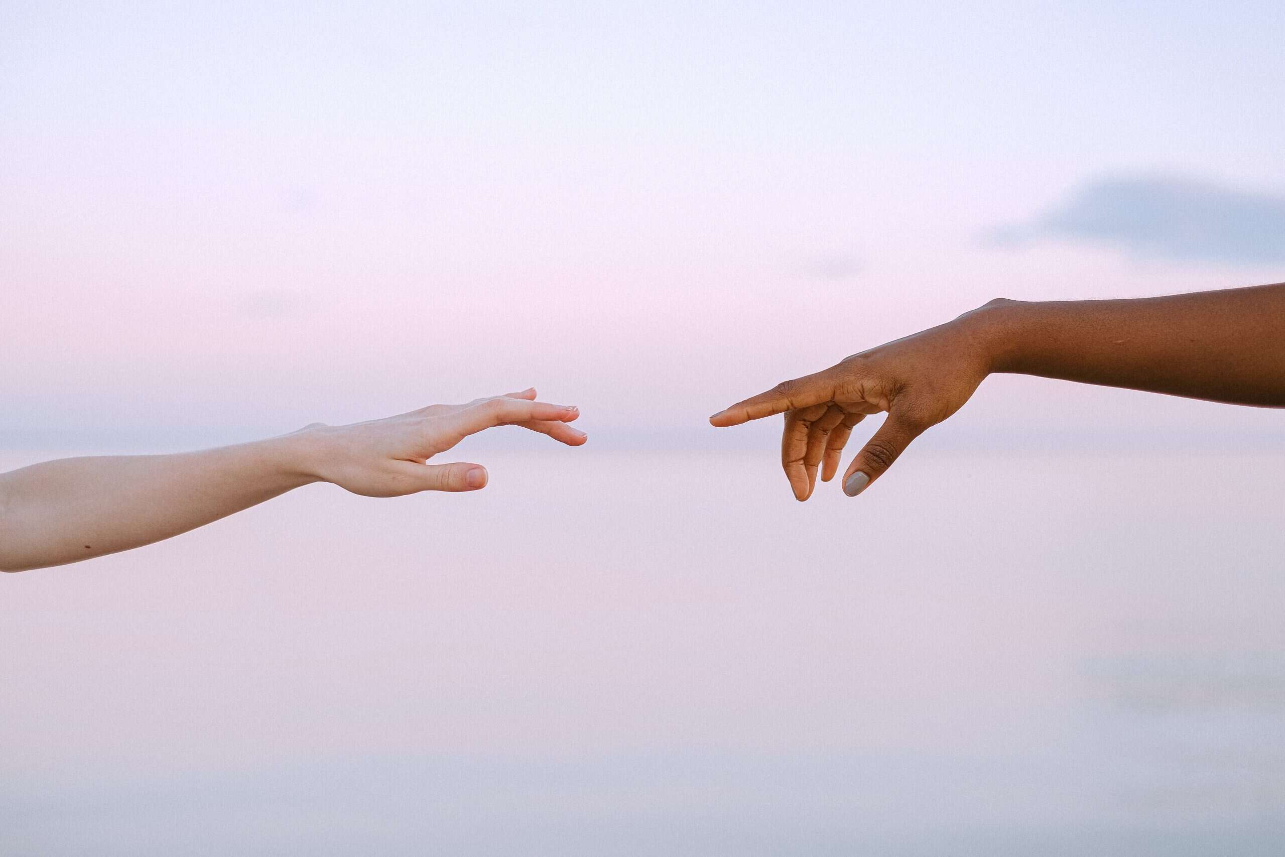 Two hands reaching out to touch, representing trust in psychotherapy