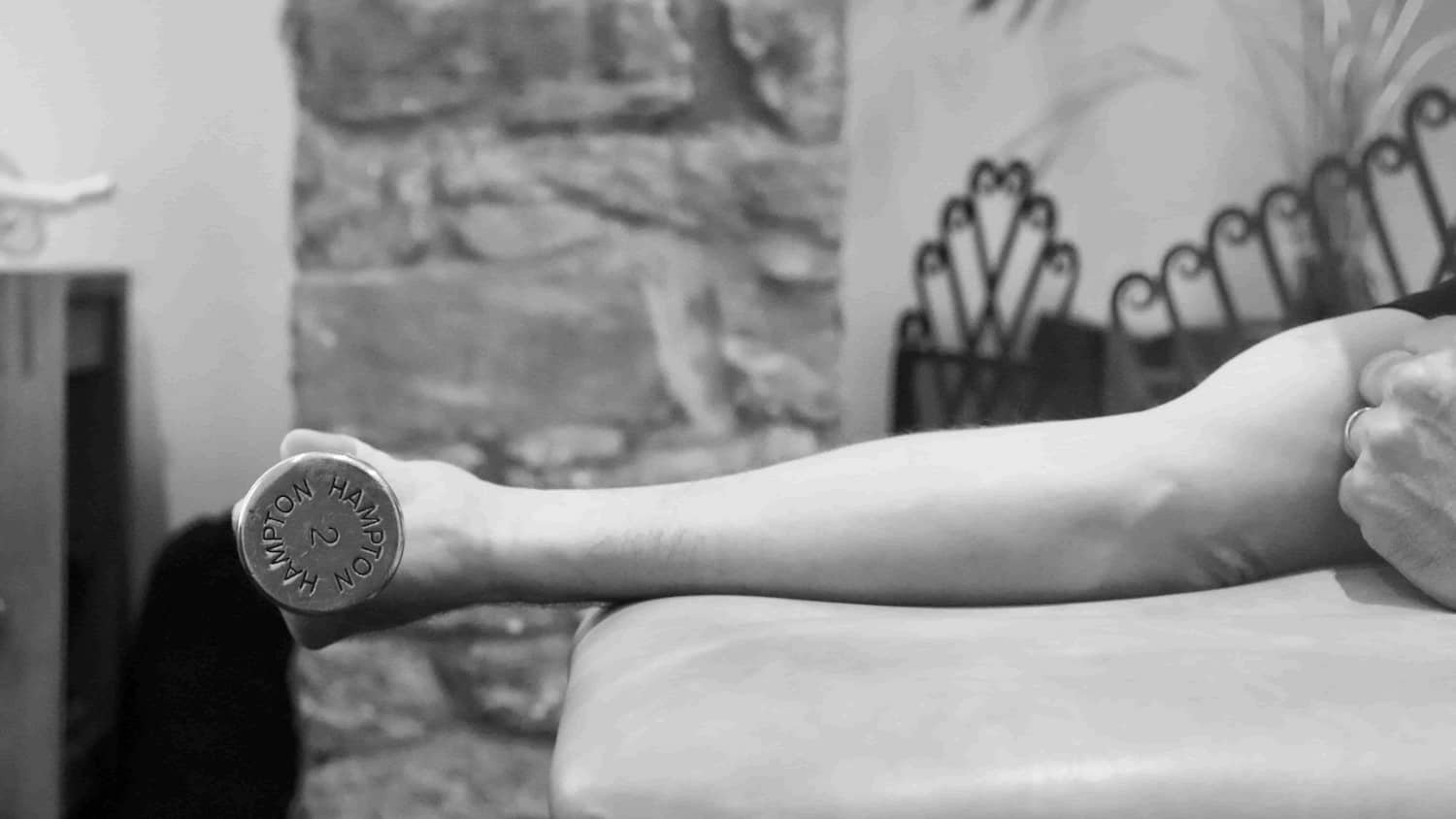 Outstretched arm holding a physio dumbbell at Trust Physio Bristol