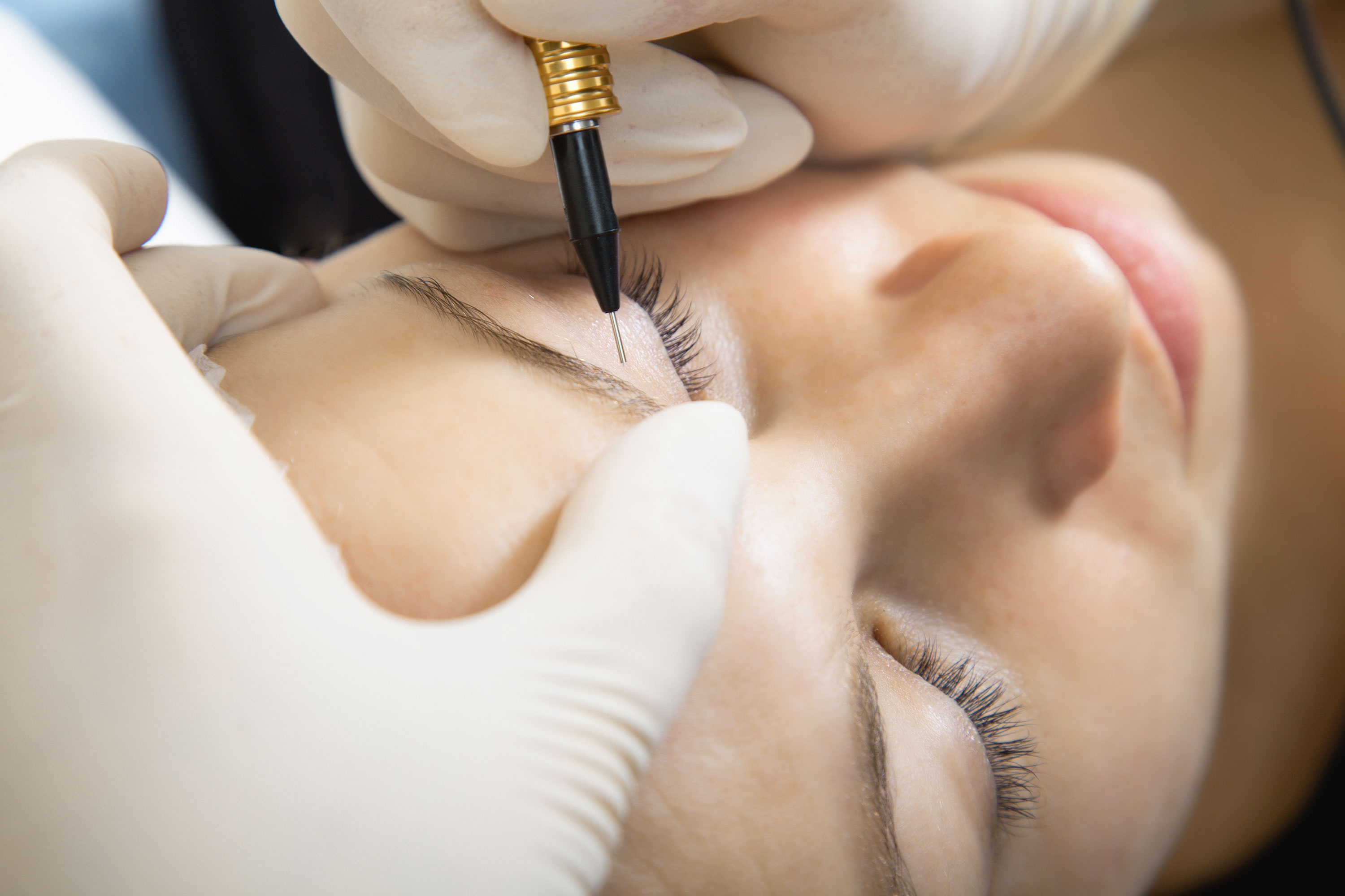 A woman receives a semi-permanent eyebrows treatment
