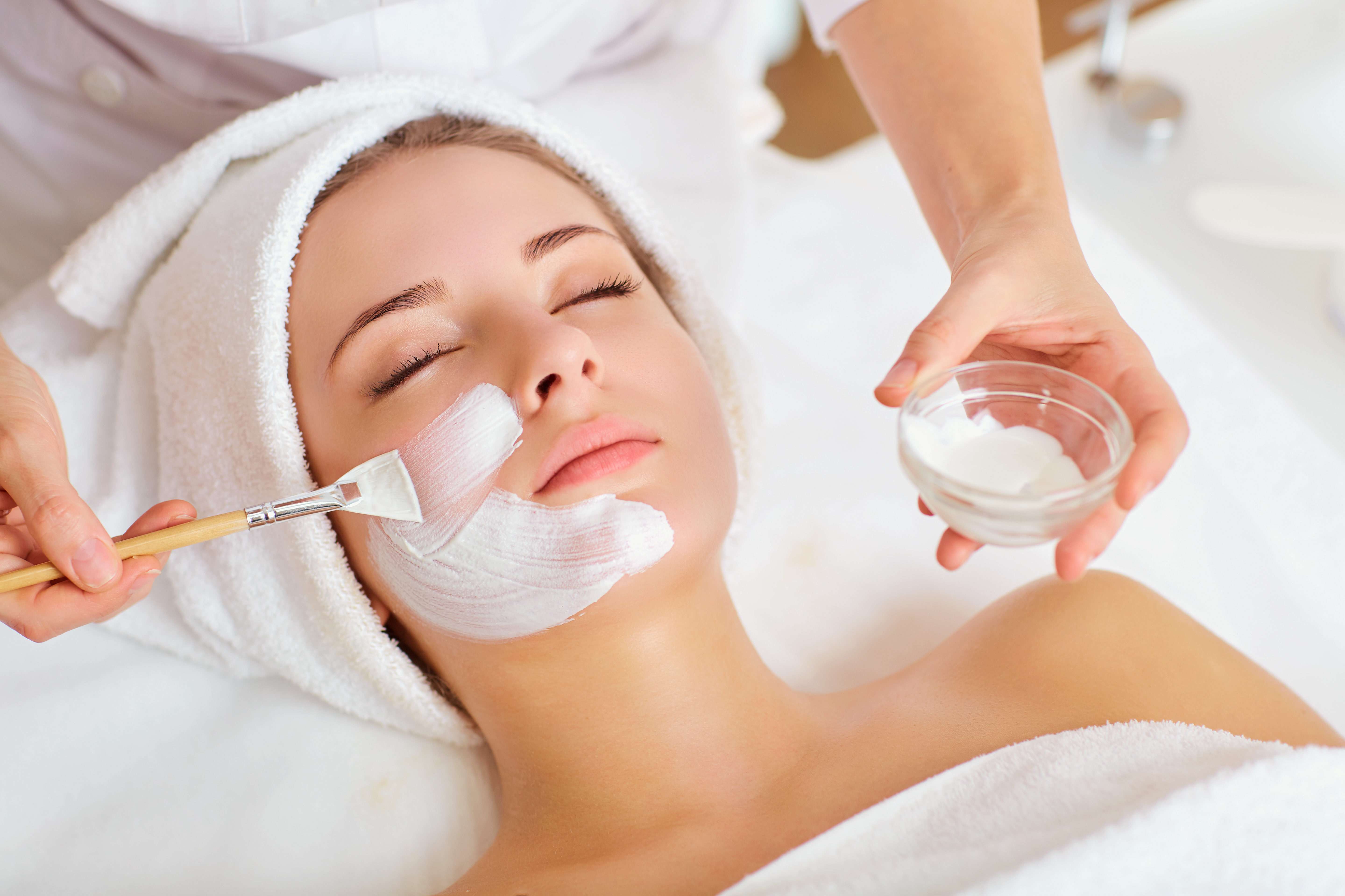 A woman relaxes as she receives a skin peel treatment