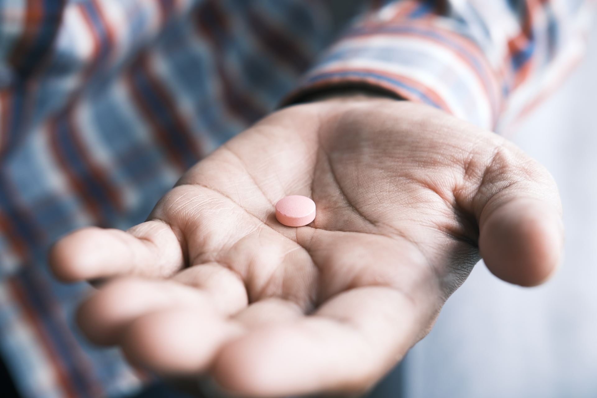 hand holding a pill (homepage Prescriptions card, generic stock photo)