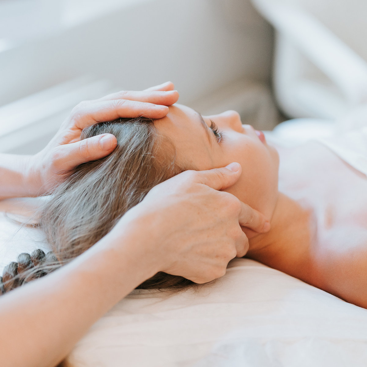 Cranial / head-and-neck osteopathy treatment of a patient lying supine