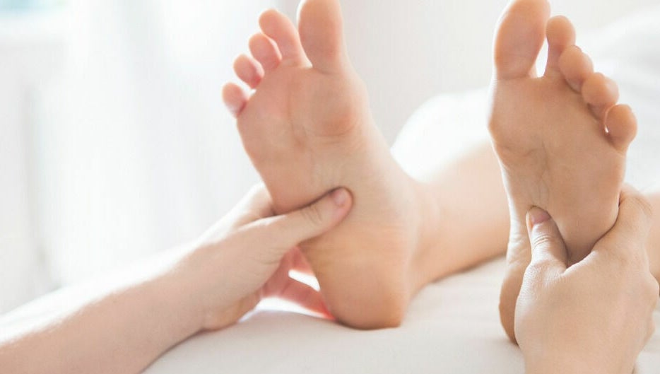 Hands giving a reflexology foot treatment