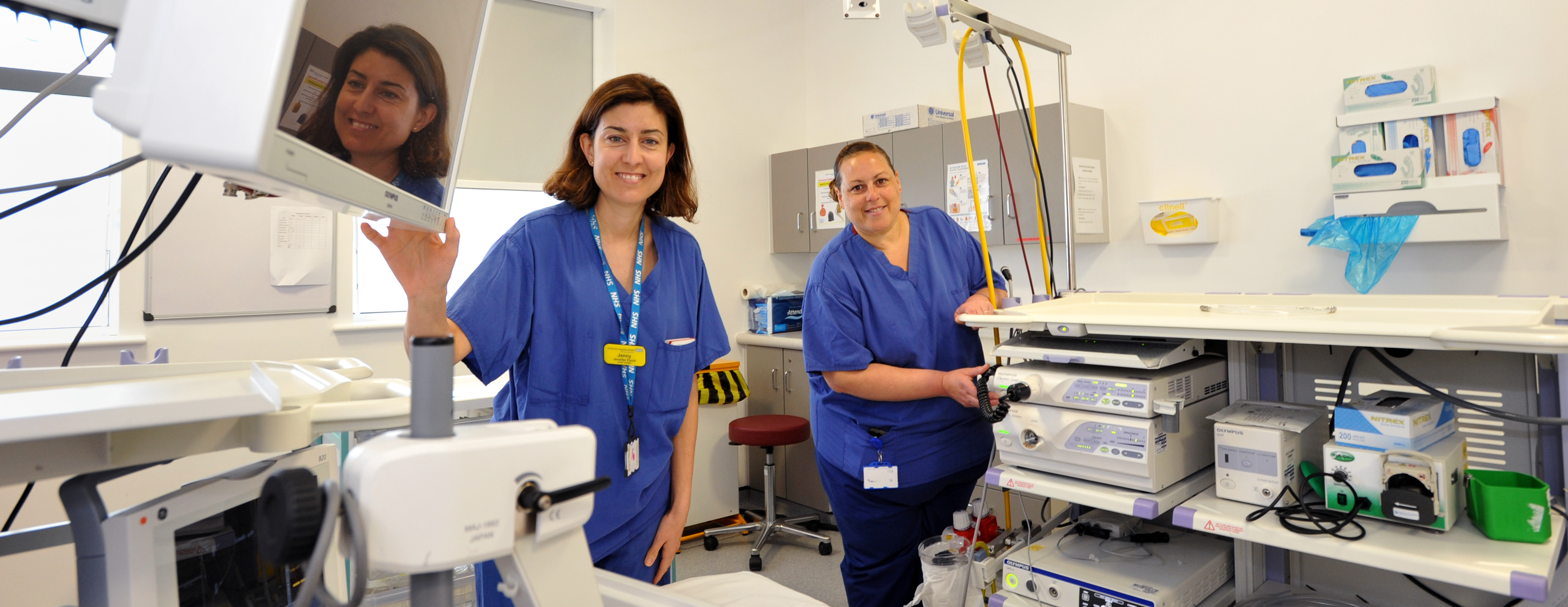 Two clinical staff in scrubs in an endoscopy / day surgery treatment room