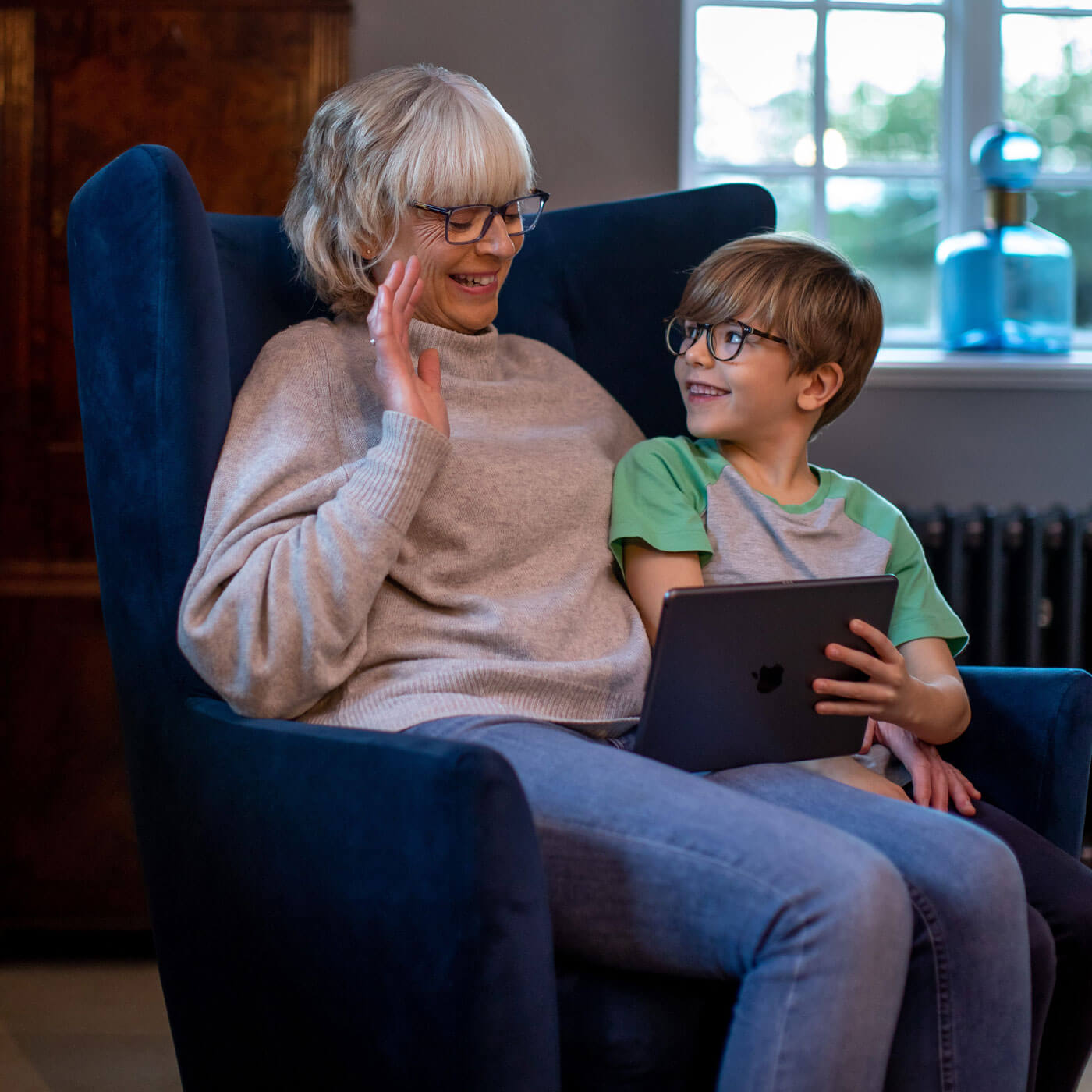 Grandmother and grandson talking on a tablet