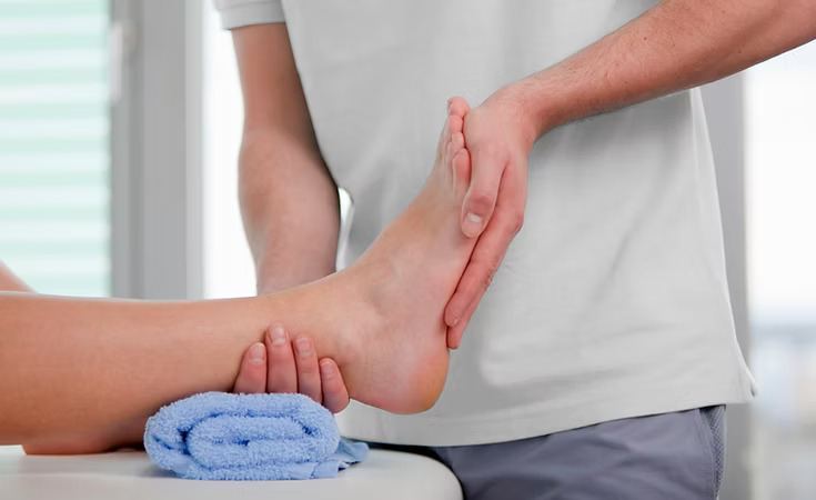 Man handles ankle for joint mobilisation